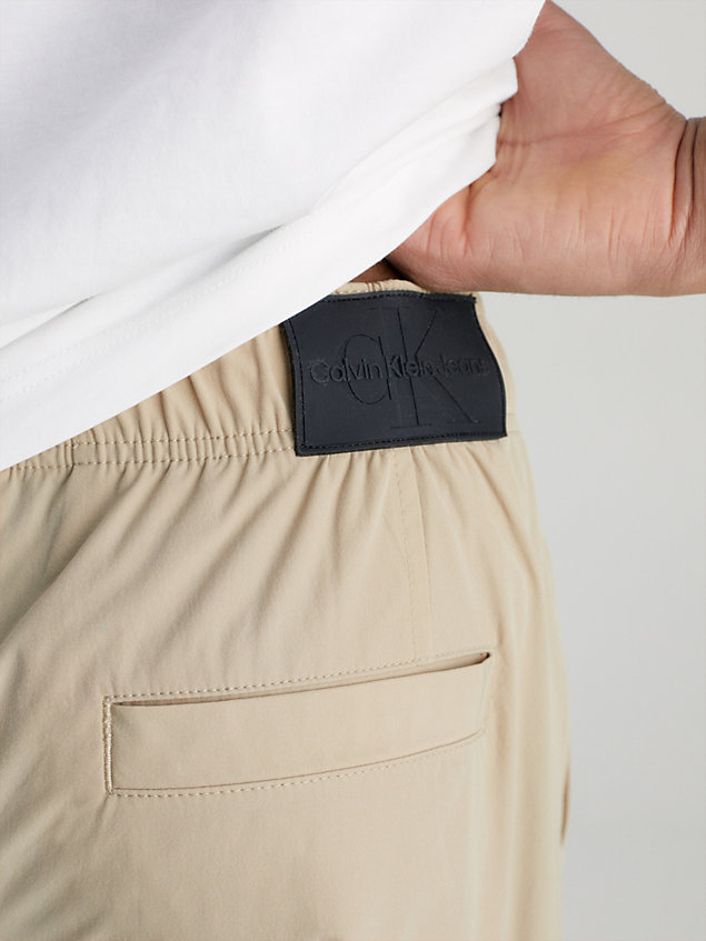 beige zwężane bojówki z przetworzonego nylonu dla mężczyźni - calvin klein jeans