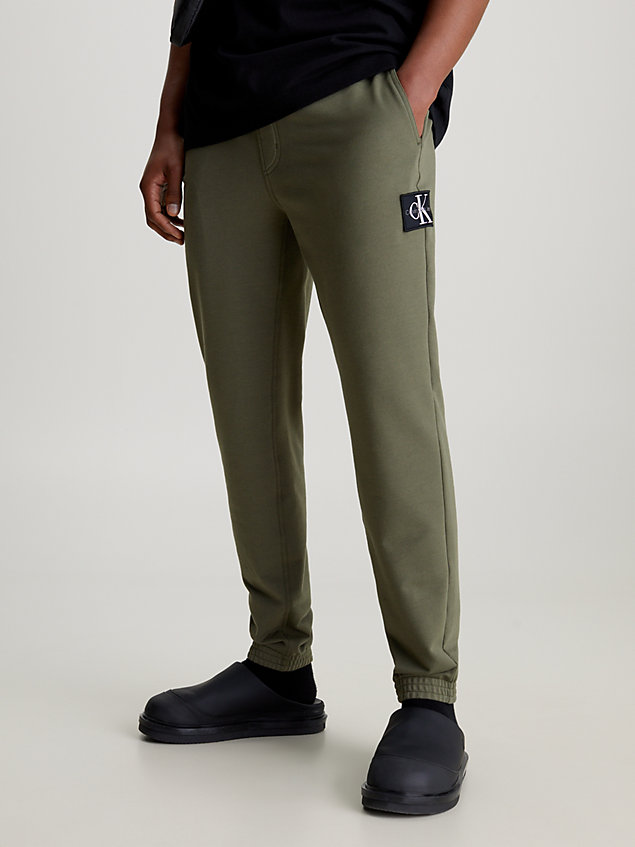 green obcisłe spodnie dresowe z naszywką z materiału frotte dla mężczyźni - calvin klein jeans