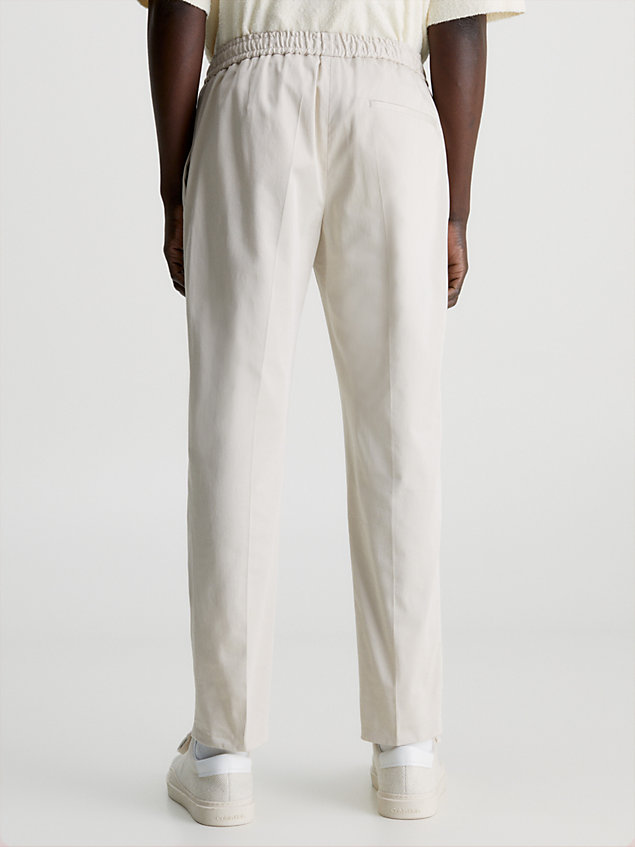 beige wąskie spodnie dresowe z satyny ze stretchem dla mężczyźni - calvin klein